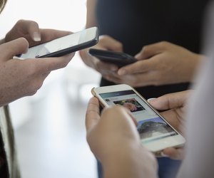Close up teenage girl friends using cell phones