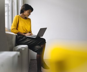 Woman sitting at the window using laptop