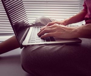 girl holds a MacBook Pro Retina on her lap and something prints