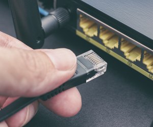 Person plugging in cable to wireless router