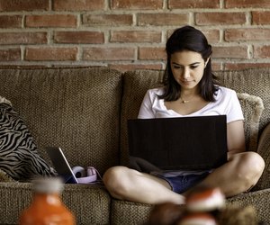Hispanic young woman working on a laptop computer at home. Home office concepts