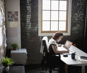 Dedicated creative businesswoman working at laptop in office