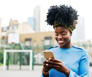 Woman using smart phone in city