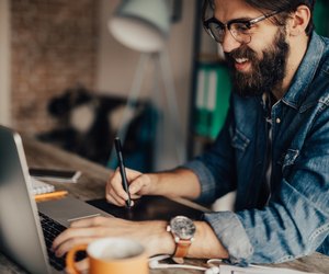 Young photographer is editing photos on laptop