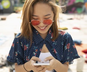 Teenage girl with sunglasses using smart phone