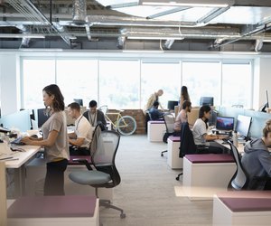 Creative business people working at computers in open plan office