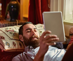 Young man relaxing with a digital tablet