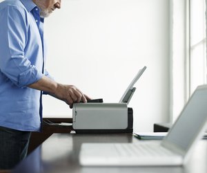 Man Using Printer At Study Table In House