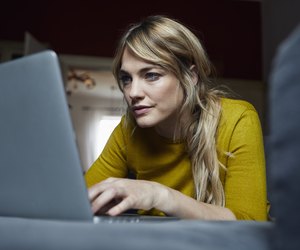 Portrait of woman lying on the couch at home using laptop
