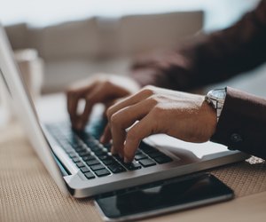 Hands typing on laptop computer