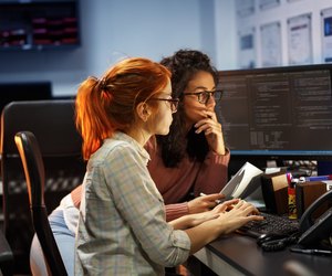 Two female programmers working on new project.They working late at night at the office.