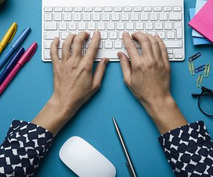 Top view of woman using computer keyboard on desk