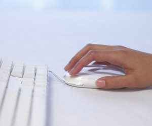 Hand with computer mouse and keyboard
