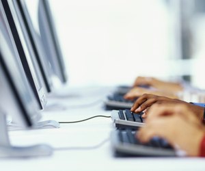 three business executives using computers in an office