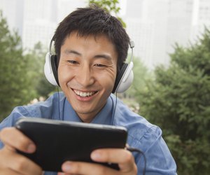 Young businessman listening to music on his MP4 player