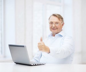 old man with laptop computer showing thumbs up
