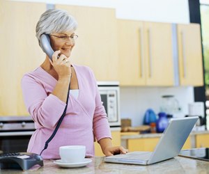 mature woman talking on a landline phone