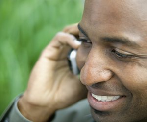 Close-up of a young man smiling talking on a mobile phone