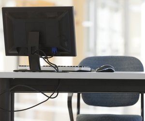 Computer equipment on desk with chair