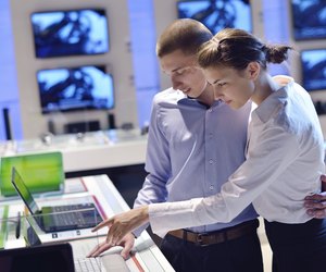 couple in consumer electronics store buying laptop