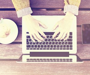 Girl with laptop, cell phone and cup of coffee