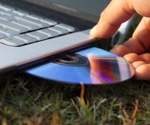 Human Hand Inserting Disc in to the Laptop
