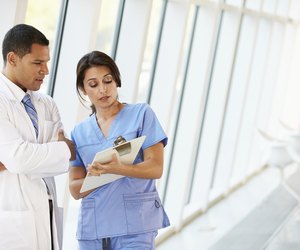 Medical Staff Having Discussion In Modern Hospital Corridor