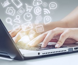 woman typing on laptop and media icons fly off