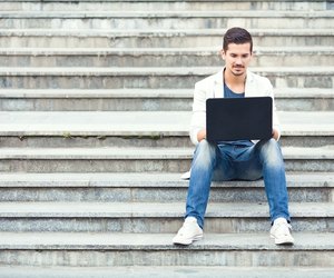 Man Sitting on the Stairs Using Laptop