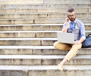 Hipster businessman with phone and laptop