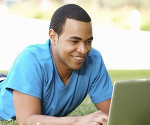 Young man using laptop outdoors