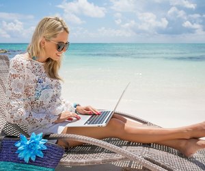 Businesswoman with computer on the beach