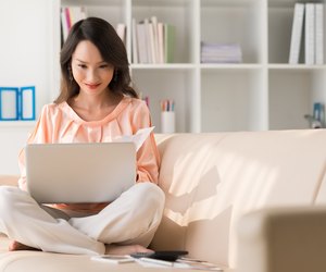 Smiling woman sitting on the couch with laptop