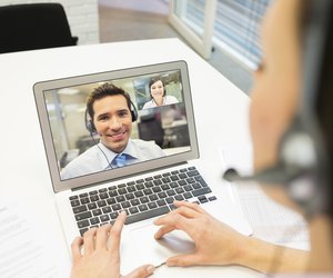 Businesswoman in the office on videoconference with headset, Skype