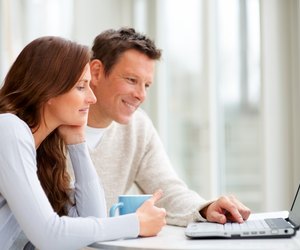 Couple using a laptop and smiling