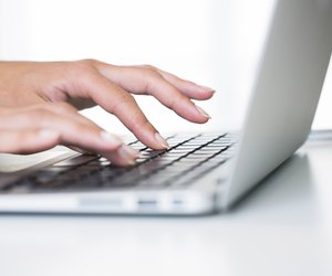 Woman hands typing on a laptop keyboard