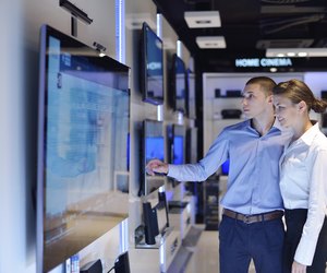 Young couple in consumer electronics store buy tv