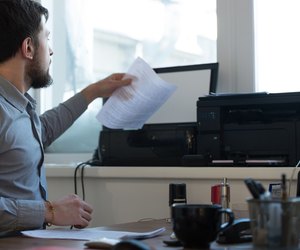 Handsome businessman scanning and printing document in office