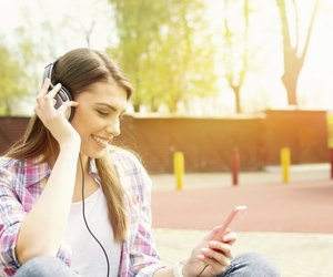 Young woman with headphones in park listening to music