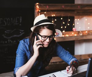 Beautiful hipster woman taking notes at modern office