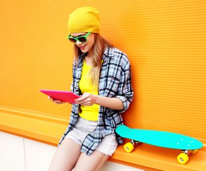 stylish cool girl using digital tablet pc in city