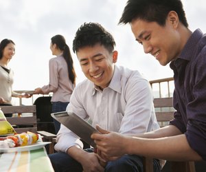 Friends Using Digital Tablet at Rooftop Barbecue