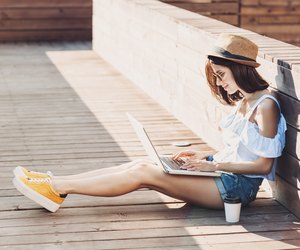 Young trendy girl using a laptop outdoors
