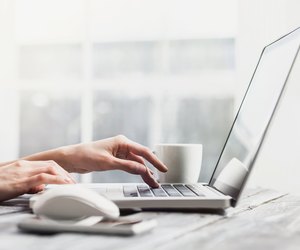 Place of work. Hands on laptop keyboard