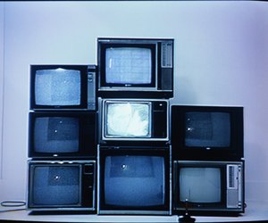 Joystick in front of stack of televisions (video still)