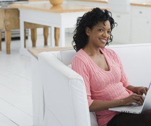 Woman sitting on couch and using laptop computer