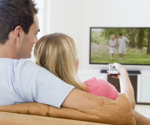 Couple in living room watching television
