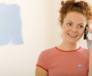Smiling woman on cell phone in new home
