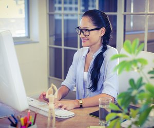 Happy young designer working at desk
