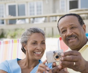 Senior man and a mature woman looking at a digital camera